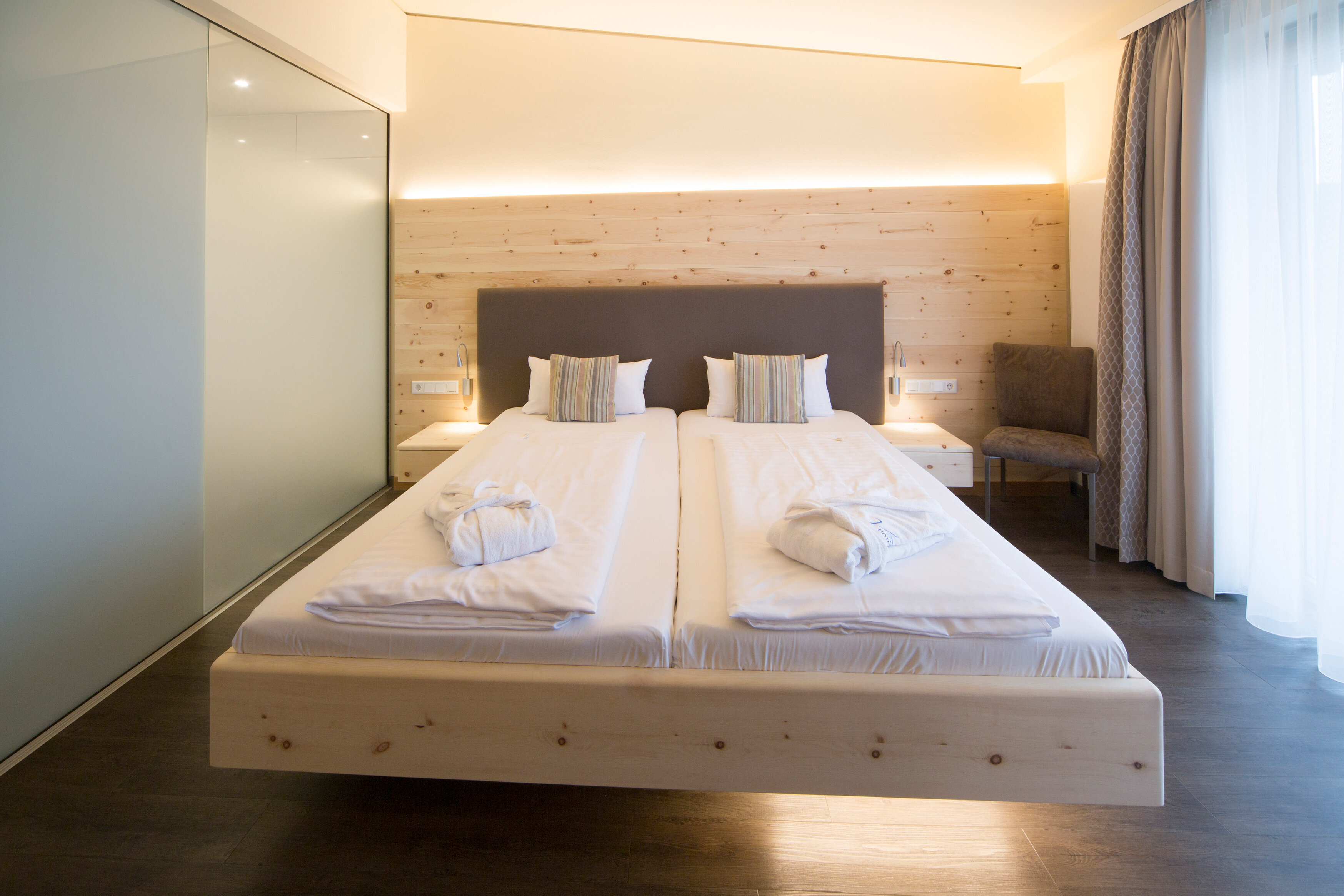 Das Bild zeigt einen Blick auf das Bett aus Zirbenholz im Doppelzimmer Zirbe 