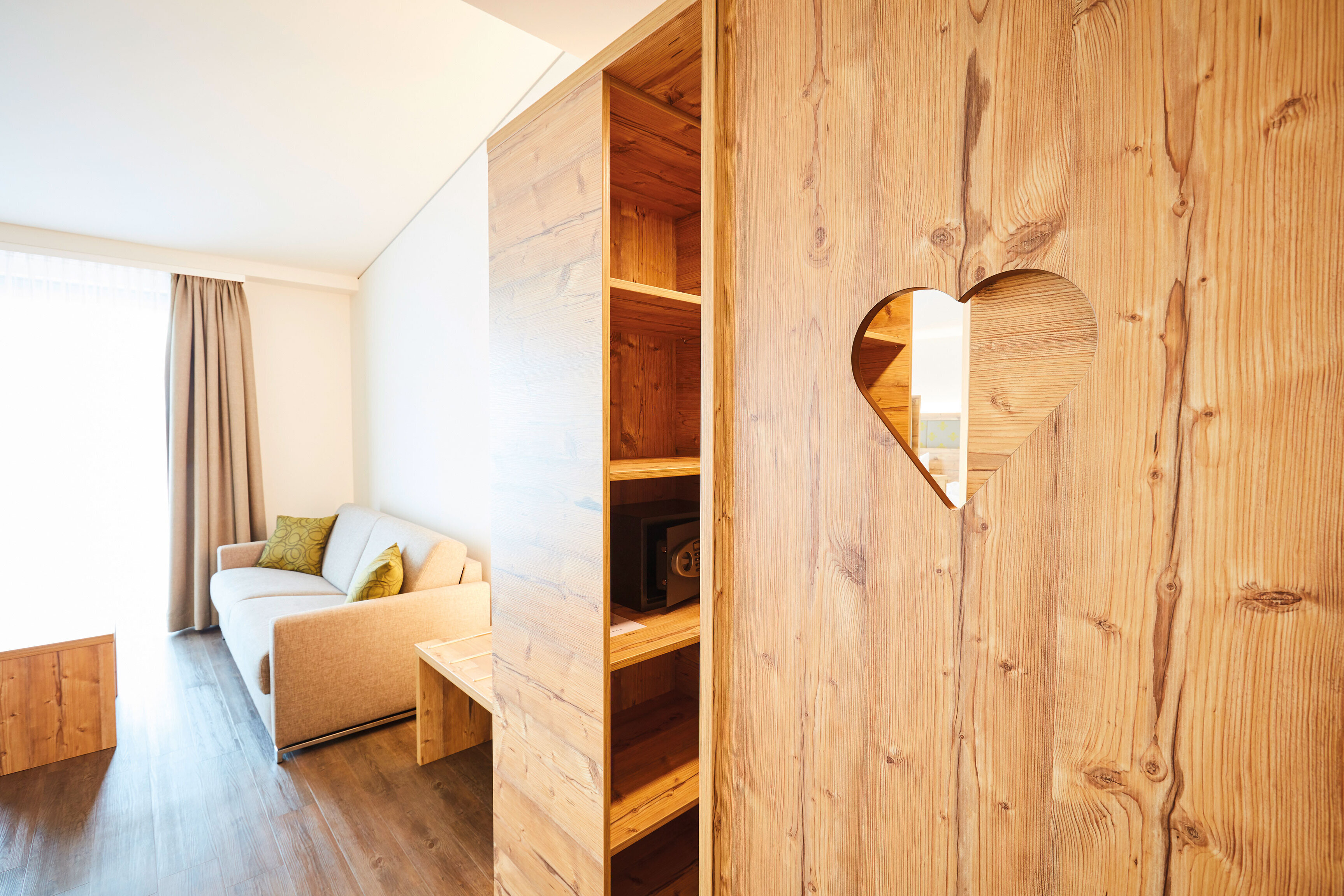 Das Bild zeigt einen Blick auf den Kleiderschrank im Doppelzimmer Superior mit einem ausgeschnittenen Herz in der Holztür