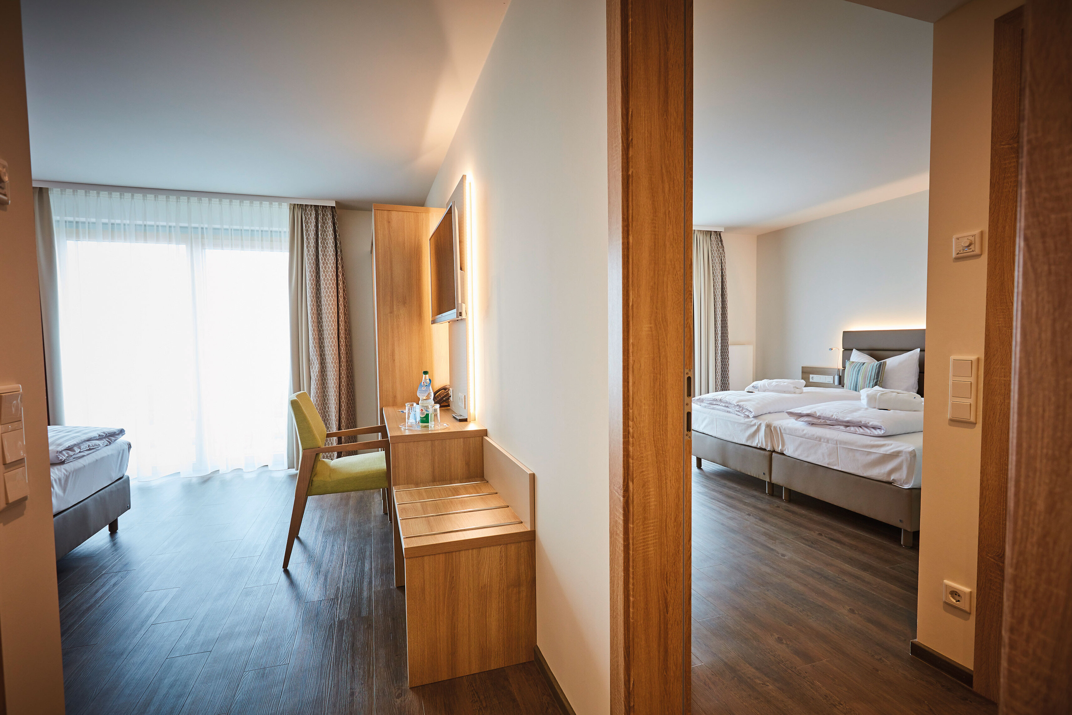 Das Bild zeigt zwei Doppelzimmer Komfort, die durch eine offene Verbindungstür miteinander verbunden sind