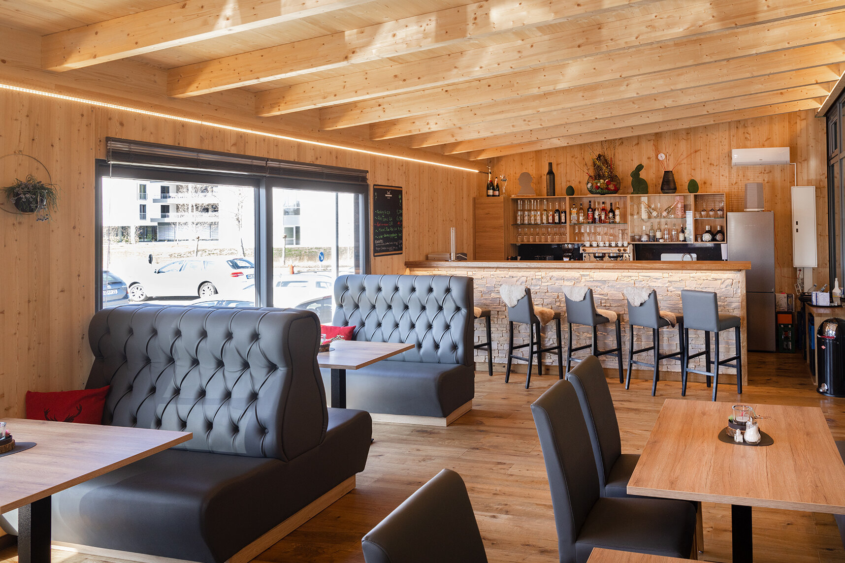 Das Bild zeigt einen Blick in die Hotelbar mit ihren verschiedenen Sitzmöglichkeiten und auf die Bar-Theke