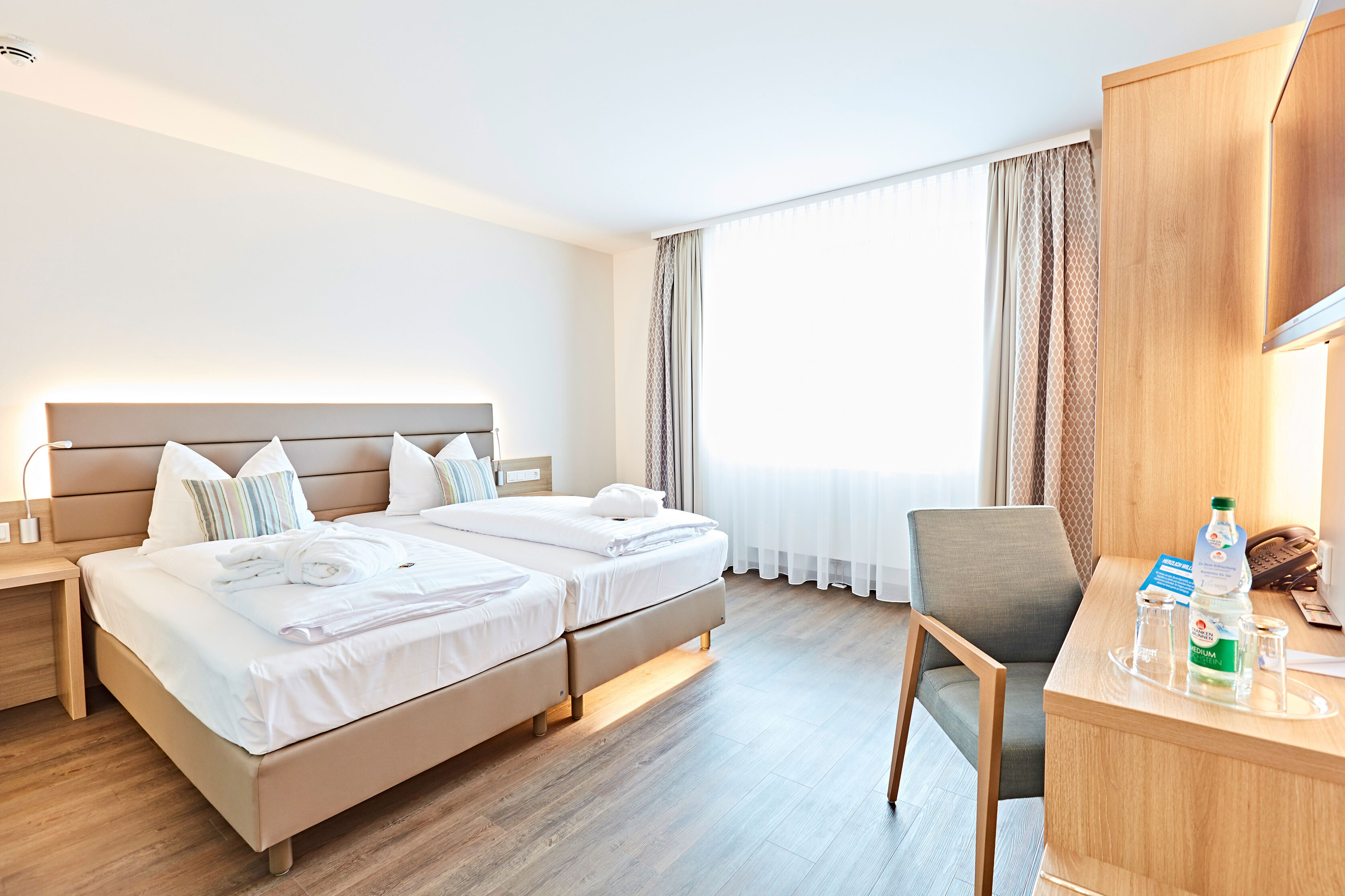 Das Bild zeigt einen Blick in das Doppelzimmer Classic mit Bett, Schreibtisch und Stuhl 